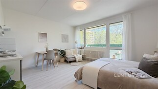 Světlý obývací pokoj s moderním nábytkem, velká okna nabízejí dostatek přirozeného světla, parketová podlaha doplňuje svěží vzhled.