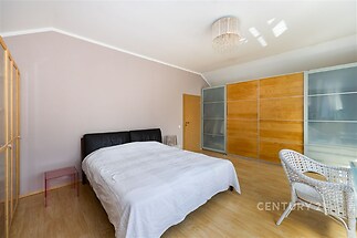 Světlá prostorná ložnice s parketovou podlahou, vestavěné skříně a moderní design.