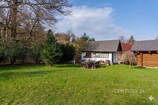 Zahrada s udržovaným trávníkem a dřevěným altánem, ideální pro venkovní posezení. Tiché prostředí, vhodné pro relaxaci.