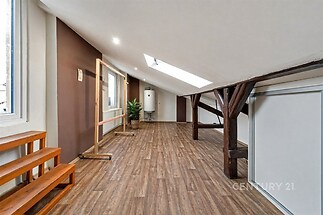 Podkrovní pokoj s dřevěnou podlahou, velké střešní okno poskytuje dostatek světla, zrekonstruovaný prostor s moderním designem.