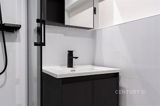 Moderní koupelna s černými doplňky, elegantní dlažbou a kvalitním sprchovým koutem vytváří funkční a stylový prostor.