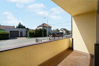 Prostorný balkon s dlažbou, nabízí výhled na klidnou ulici a okolní domy. Balkón je ideální pro venkovní posezení, v dobrém stavu.