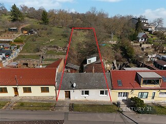 Řadový rodinný dům se zahradou ve svahu, rekonstruovaný exteriér, cihlová konstrukce, klidná lokalita, potenciál pro úpravy.