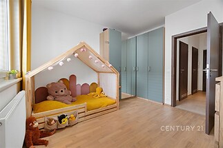 Dětský pokoj s parketovou podlahou, vestavěnými skříněmi a hravým dřevěným postelovým rámem, moderní a světlý prostor.