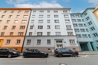 Bytový dům s moderní fasádou v klidné ulici, světlé omítky a plastová okna, dobrá dostupnost a občanská vybavenost poblíž centra města.