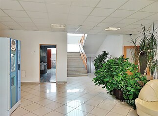 Společné prostory s keramickou dlažbou a světlým stropem, obsahující schodiště a velká okna, vytvářejí moderní a vzdušný dojem.