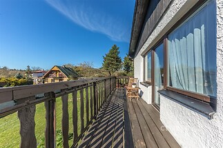 Dřevěný balkon s výhledem do zahrady, dřevěná podlaha, velká okna, klidná lokalita, vhodné pro milovníky přírody.