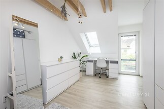 Prostorná ložnice s parketovou podlahou, vestavěnými skříněmi a moderním psacím stolem, světlá místnost díky velkému střešnímu oknu.