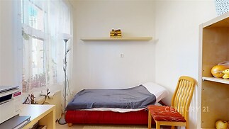 Světlý dětský pokoj s dřevěnou podlahou, velkými okny a minimalistickým vybavením, ideální pro útulný a moderní domov.