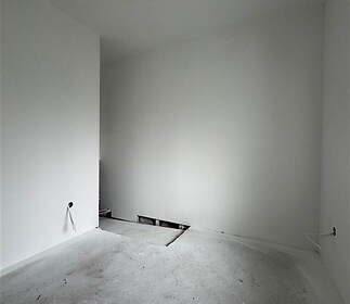 Prázdná místnost ve výstavbě s betonovou podlahou, připravená pro instalaci zařízení, bílé stěny, moderní design, vysoké stropy