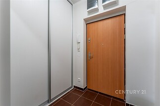 Vstupní hala s dlažbou, vestavěné skříně a dřevěné vstupní dveře, moderní interiér v rekonstruovaném stavu.