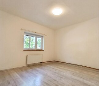 Světlý obývací pokoj s parketovou podlahou, velkými okny a moderním osvětlením, v dobrém stavu vhodný pro rodinné bydlení
