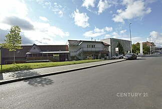 Jedná se o exteriér komerční budovy s moderní fasádou a velkým parkovištěm. Budova je umístěna v atraktivní lokalitě blízko hlavní silnice.