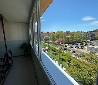 Zasklená lodžie s výhledem na park, moderní úprava, prostorná dispozice, světlé provedení.