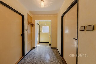 Chodba s dlažbou, světlá dispozice a vestavěné skříně vytvářejí praktický prostor v rekonstruovaném bytě.