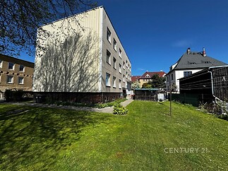 Moderní bytový dům se zahradou, světlá fasáda, klidná lokalita, dobrý stav.