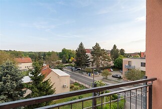 Výhledový balkon, moderní zábradlí, klidná rezidenční čtvrť.
