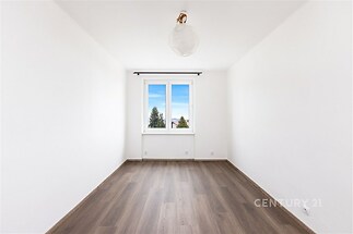 Světlá ložnice s parketovou podlahou, velká okna s výhledem, moderní světlý interiér.