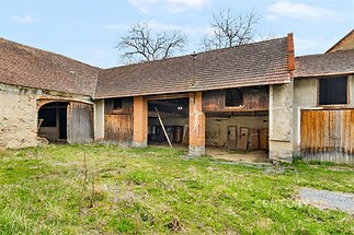 Staré zemědělské stavení s dřevěnými vraty, kamennými zdmi a doškovou střechou, vhodné pro rekonstrukci nebo přestavbu