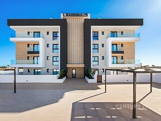 Moderní bytový dům s velkými okny a balkony na slunečné terase; moderní architektura, kombinace dřeva a světlé fasády.