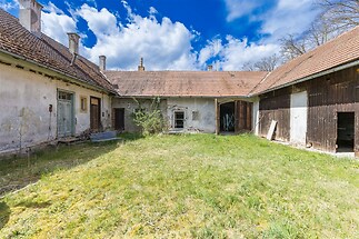Prostorný dvůr se staršími budovami, trámový strop, dlážděný povrch, ideální k rekonstrukci, potenciál pro rozšíření obytného prostoru.