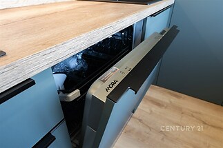 Kuchyň s vestavěnou myčkou, moderní design, dřevěné pracovní desky, parketová podlaha, modrá skříňka, stylový a praktický interiér