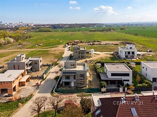 Moderní rezidenční čtvrť s novostavbami, rovná střecha, velká okna, klidné prostředí, výhled na krajinu