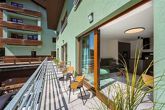 Prostorná terasa s moderními francouzskými okny, dlažba na podlaze, výhled na okolní budovy, ideální pro relaxaci a outdoorové posezení.