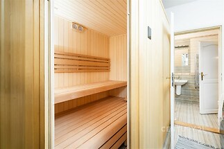 Sauna z kvalitního dřeva, sousedící s moderní koupelnou s dlažbou, nabízí relaxaci a pohodlí v nově rekonstruovaném domě.