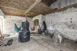 Prostorná stodola s kamennými zdmi, dřevěnými trámy a betonovou podlahou, vhodná k rekonstrukci či úpravám dle vlastních představ.