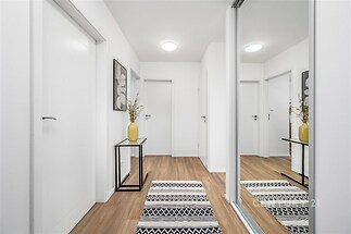 Vstupní hala s parketovou podlahou, vestavěné skříně a moderní osvětlení vytváří světlý a elegantní prostor.