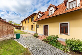 Dvoupatrový rodinný dům s červenou střešní krytinou, kvalitní omítka a dlážděná příjezdová cesta, okolní upravená zahrada nabízí klidné prostředí