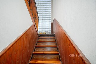 Dřevěné schodiště s dřevěným obložením, skleněná tvárnice, světlý prostor, moderní design, elegantní řešení.