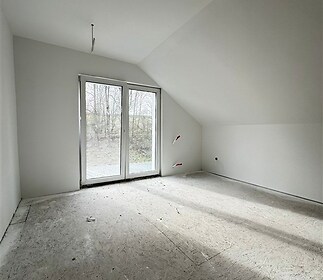 Ložnice s velkými okny, moderním stylem a připravená pro parketovou podlahu. Světlý prostor s výhledem do zahrady.