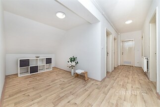 Prostorná chodba, parketová podlaha, moderní osvětlení, světlý interiér, minimalistický nábytek, čerstvě vymalováno, klidná atmosféra.