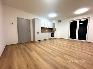 Moderní kuchyň s parketovou podlahou a velkými okny, vestavěná kuchyňská linka v rekonstruovaném interiéru, světlý a otevřený prostor