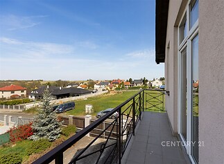 Balkón s výhledem na zahradu s moderní dlažbou a elegantním zábradlím, skvělý prosluněný prostor v klidné lokalitě.