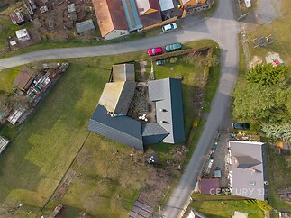 Letecký pohled na moderní rodinný dům s velkou zahradou a novou střešní krytinou, nacházející se v klidné rezidenční lokalitě.