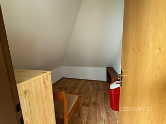 Malá podkrovní místnost, dřevěný nábytek, parketová podlaha, vhodná jako pracovna nebo útulný pokoj pro hosty.