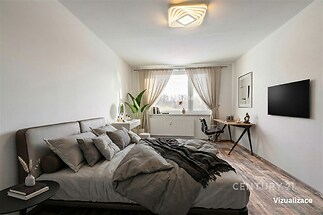 Prostorná ložnice s parketovou podlahou, moderní osvětlení, velká okna s průhlednými závěsy, stylový pracovní kout, příjemná atmosféra.