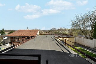 Velká střešní terasa s výhledem na krajinu, železné zábradlí, rovná střecha, vhodná pro venkovní posezení, klidná lokalita, panorama přírody.