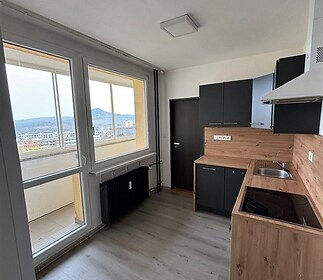 Moderní kuchyň s parketovou podlahou a velkými okny nabízí skvělý výhled, dřevěný obklad doplňuje moderní design a stylový vzhled.