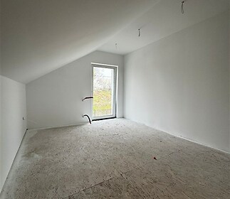 Podkrovní pokoj s velkými okny, moderní světlý prostor s dřevěnými podlahami, ideální pro rekonstrukci a osobní úpravy.