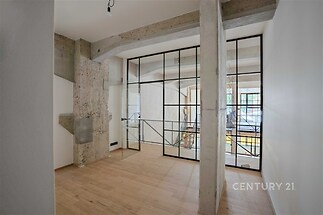 Industriální obývací pokoj, parketová podlaha, velká okna, moderní styl, železobetonové prvky, světlý interiér