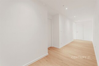 Světlá chodba s dřevěnou podlahou, moderní LED osvětlení, nově rekonstruovaný interiér s hladkými bílými stěnami