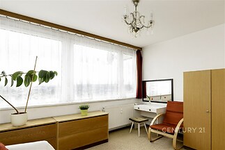 Světlá ložnice s velkými okny.