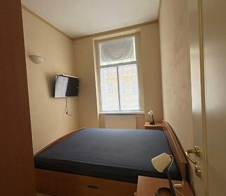 Útulná ložnice, dlažba na podlaze, velké okno, moderní osvětlení, vestavěná skříňová úložná řešení pro maximální prostor.