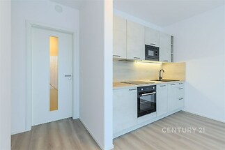 Moderní kuchyň s vestavěnými spotřebiči, světlá dvířka, parketová podlaha, minimalistický styl, ideální pro novostavbu.