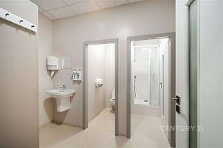 Moderní koupelna s dlažbou, sprchovým koutem a světlými stěnami, v perfektním stavu, ideální pro moderní bydlení.