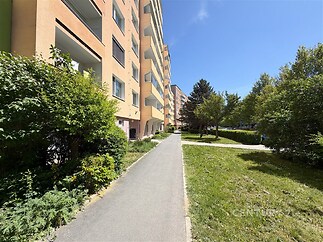 Pěkný obytný dům s moderní fasádou, obklopený zelení. Tichá lokalita poskytuje klidné prostředí. Dům je v dobrém stavu s balkonem a upraveným okolím.